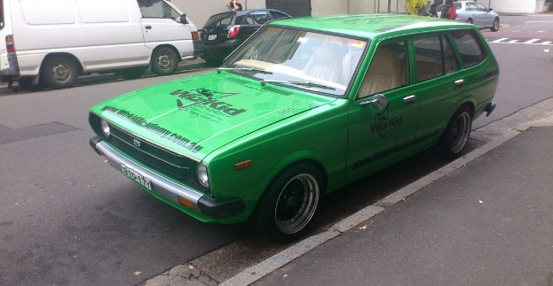 Eine Person zwischen Fahrzeugen auf der Straße.
