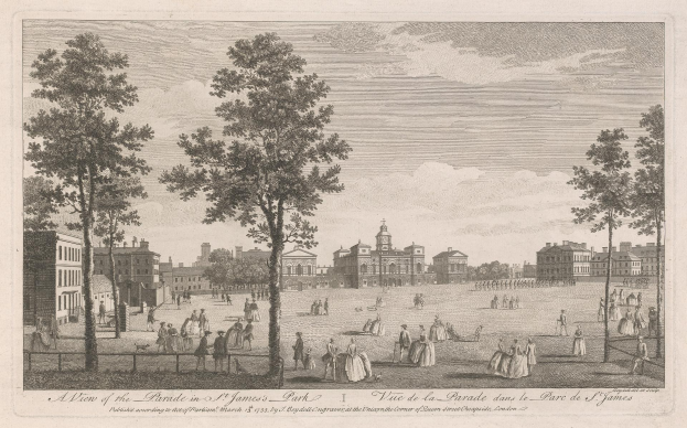 Eine Gruppe von Menschen, die während eines Umzugs in St. James Park steht und sitzt, mit Bäumen und Gebäuden im Hintergrund bei einem bewölkten Himmel.
