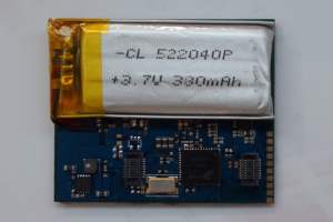 Nahaufnahme einer Handy-Batterie auf einer Leiterplatte mit darauf gedrucktem Text, die auf einer weißen Oberfläche liegt.