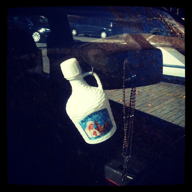 Ein Auto steht mit einer Kette und einer Flasche am Straßenrand.