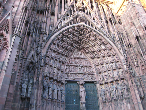 Der Eingang zum Kölner Dom in Köln, Deutschland, mit detaillierten Schnitzereien, Skulpturen und einer großen Tür am Boden.