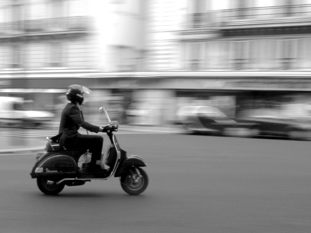 Eine Person fährt mit einem Scooter auf einer Straße.