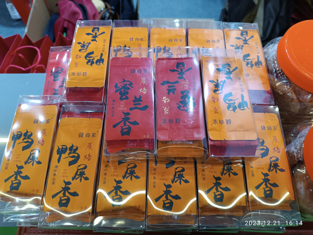 Ein Tisch voller verschiedener verpackter Lebensmittel und Gegenstände, mit einer Person im Hintergrund bei einer Chinesischen Neujahrsfeier.