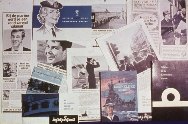 Zeitungen auf einem Tisch mit Bildern eines lachenden Mannes und einer ernsten Frau, beide mit kurzem dunklem Haar und legerer Kleidung.