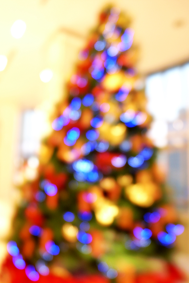 Ein unscharfer Schnappschuss eines Indoor-Weihnachtsbaums mit Lichtern und Schmuck.
