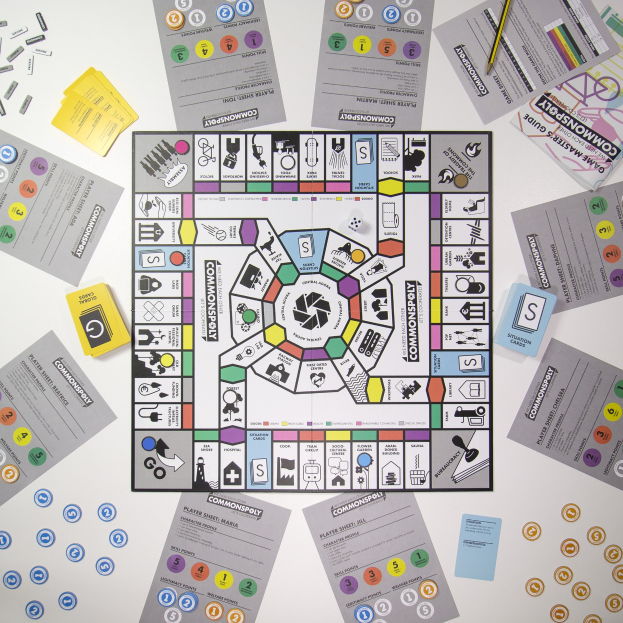 Ein Monopoly-Brettspiel auf einem Tisch mit Spielkarten, Papieren und einem Bleistift, der um das Spielbrett herum verstreut ist.