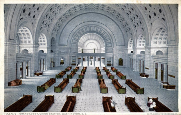 Großer Eingangsbereich des Union Station, Washington, D.C., mit Reihen von Holzbänken, hohen Säulen, gewölbten Fenstern und hohen Decken.