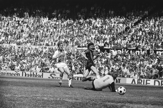 Schwarzes und weißes Foto von Männern, die auf einem Feld Fußball spielen, mit Zuschauern im Hintergrund und einer Tafel mit der Aufschrift "Bundesliga 1978-79 Ajax 1-1 Hannover 96."