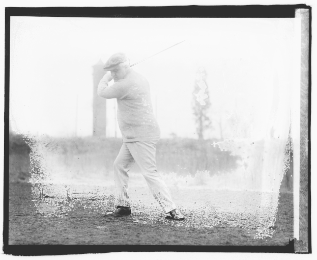 Schwarz-weiß-Foto eines Mannes, der einen Golfschläger auf einem grasbewachsenen Bereich mit Bäumen und Pflanzen im Hintergrund schwingt.