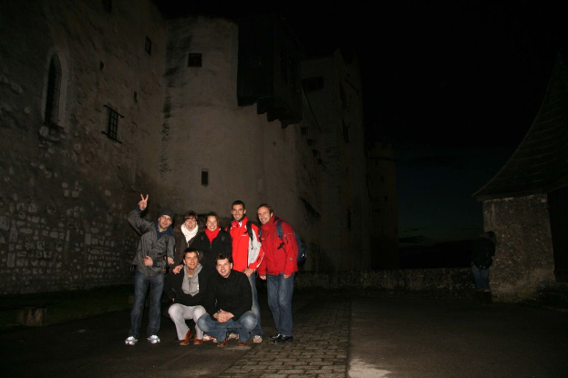 Menschen in der Mitte einer nächtlichen Szene mit einem Schloss im Hintergrund.