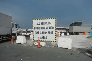 Ein Lastwagen auf einem Parkplatz neben einem Schild mit der Aufschrift "Alle Fahrzeuge nach Mexiko".