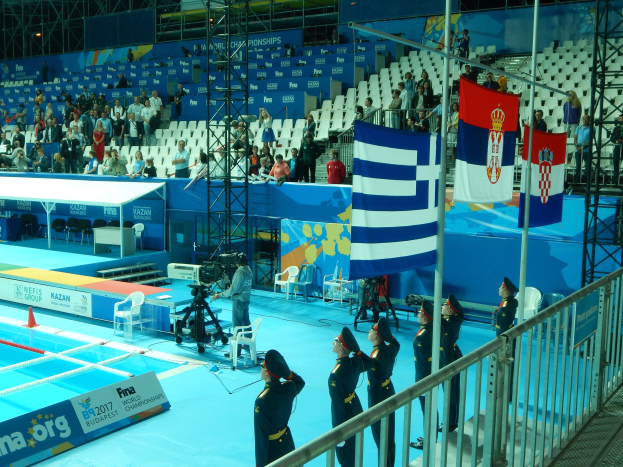 Eine Gruppe uniformierter Nationalgardisten steht auf einem Swimmingpoolgelände mit Ausrüstung, Sitzgelegenheiten und einem Banner.