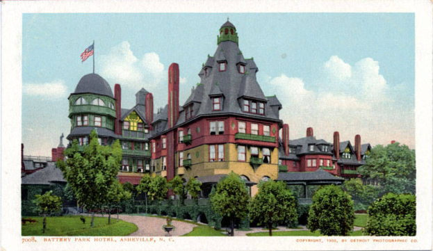 Eine alte Postkarte zeigt das Battery Park Hotel in Asheville, North Carolina, ein großes Gebäude mit einer Fahne oben, umgeben von Bäumen, Pflanzen und Gras, mit einem Weg im Vordergrund und Text unten.