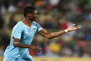 Ein Fussballspieler in einem blauen Trikot feiert mit ausgestreckten Armen nach einem Tor