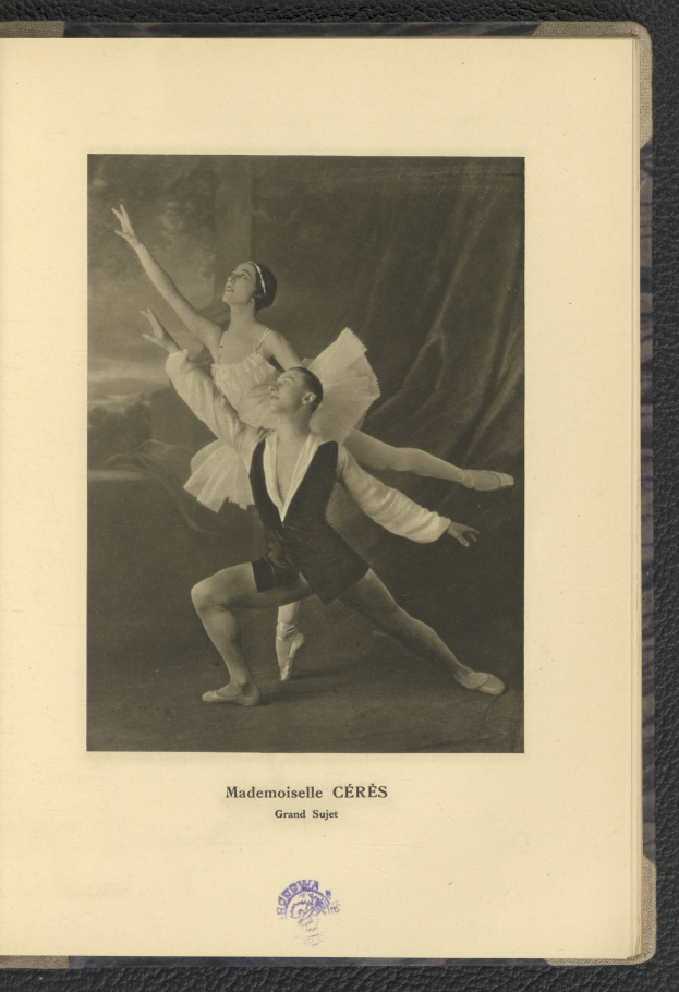 Ein Schwarz-Weiß-Foto eines Mannes und einer Frau in Ballettkleidung, die perfekt synchron tanzen, wobei der Mann ein weißes Tutu trägt und die Frau ein pinkes Kleid, Text unten im Rahmen.