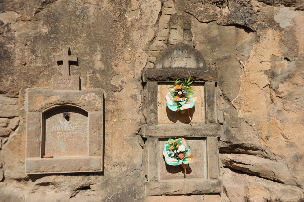 Gedenktafeln mit Blumensträußen davor