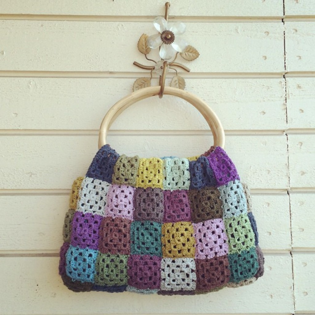 Eine Handtasche wird gegen einen einfarbigen Hintergrund gezeigt.